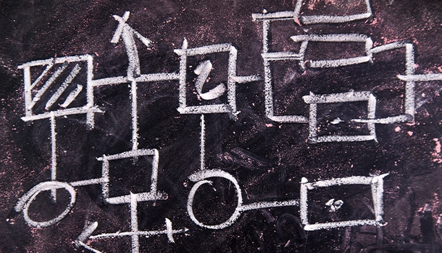 A close-up of a diagram drawn in chalk on a blackboard.