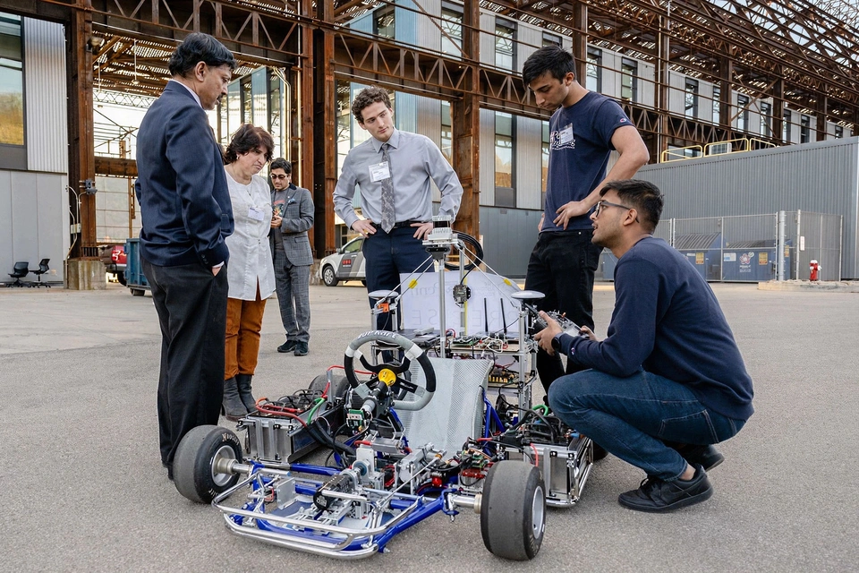 SEI staff collaborating with CMU students in the robotics lab.