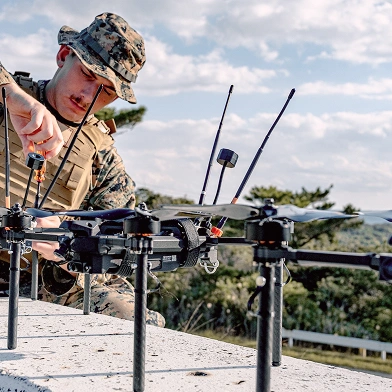 Soldier in uniform assembling drones.