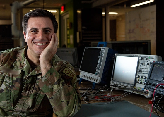An airman posing next to equipment.