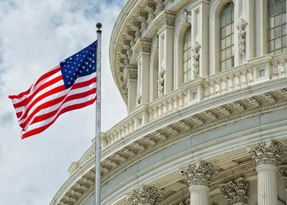 Upper corner of the U.S. Capital Building with a flag