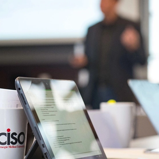Close-up of a tablet and a CiSO CMU branded mug.