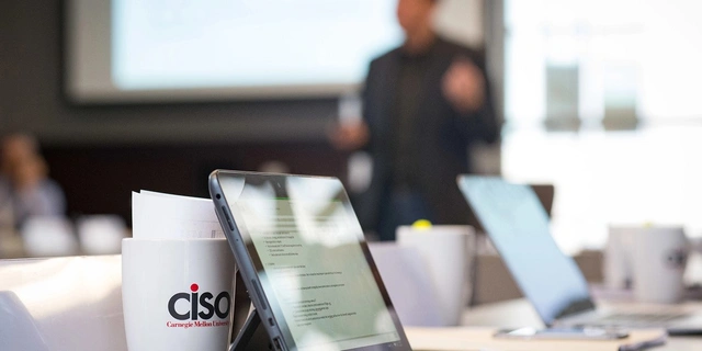 Close-up of a tablet and a CiSO CMU branded mug.