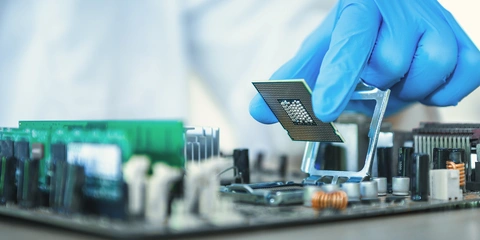Gloved hand installing a computer processor chip.