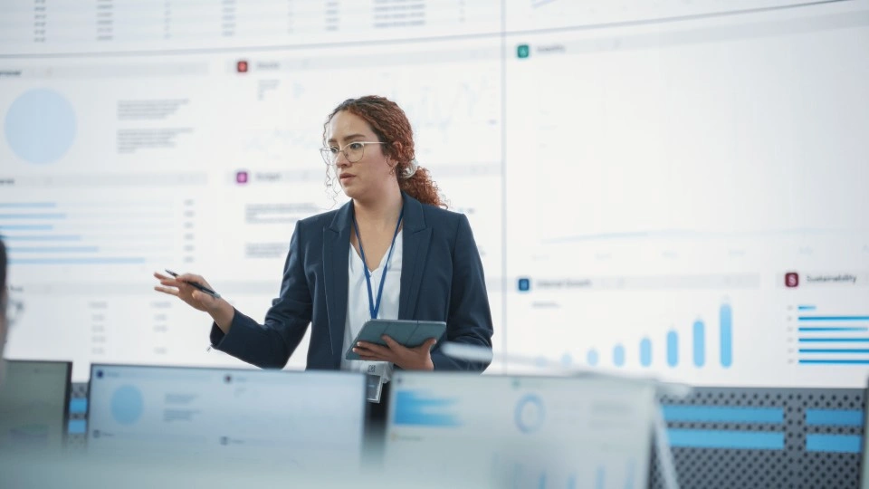 A woman presents business risk management data.