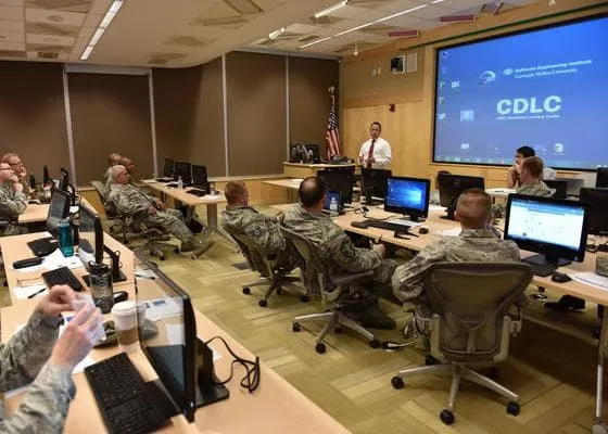 A group of military personnel watching a presentation.