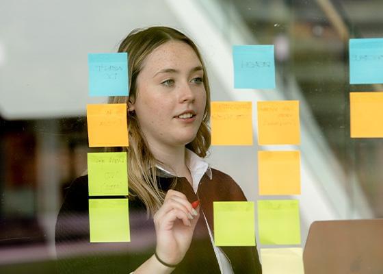 Photo of an intern conducting a whiteboard exercise with Post-it notes