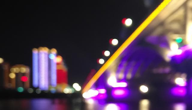 A bridge lit in purple at night.